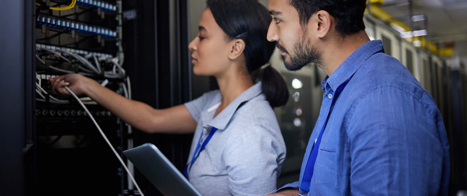 Two people looking over server hardware