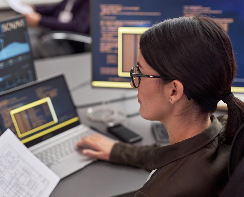 Network management worker looking over screens