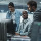 Side view of three cybersecurity professionals working together at a computer